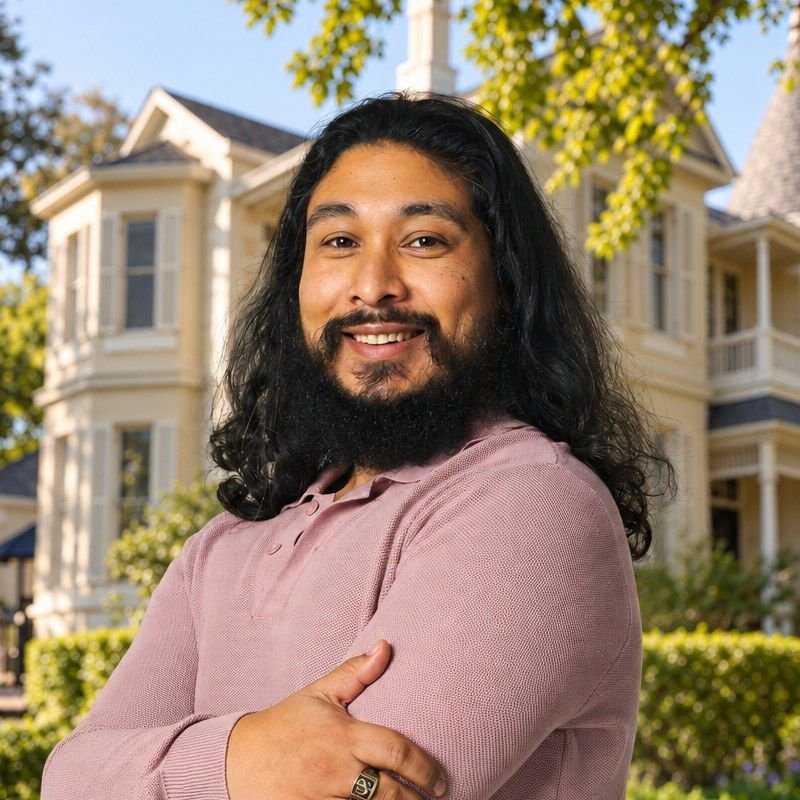 Ebrahim Behardien, General Manager of Victoria Haus, smiling in the garden in front of the house.